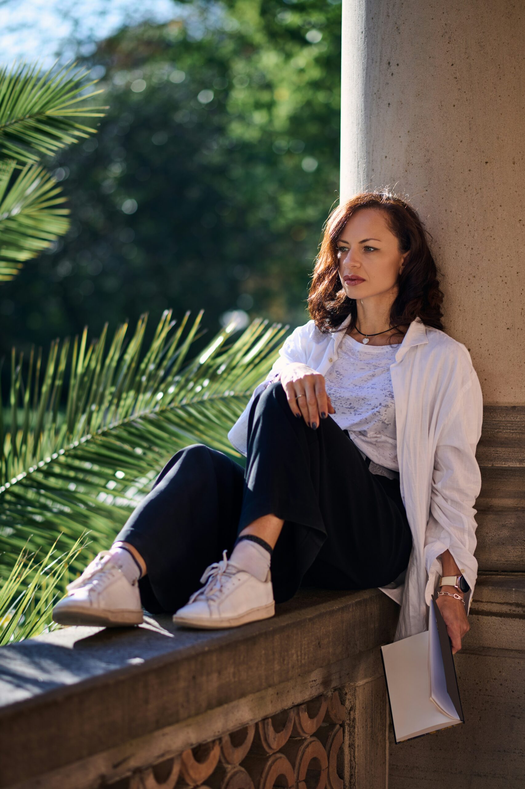 A woman sits on a ledge, considering "Is A Formal Evaluation Right For Me?" with a thoughtful expression.