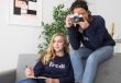 Two women sit on a couch together, one taking looking through a camera while the other takes notes, representing NeuroSpark Health's expertise in women/AFAB autism diagnosis.