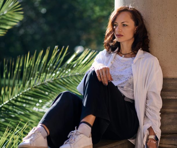 A woman sits on a ledge, considering "Is A Formal Evaluation Right For Me?" with a thoughtful expression.
