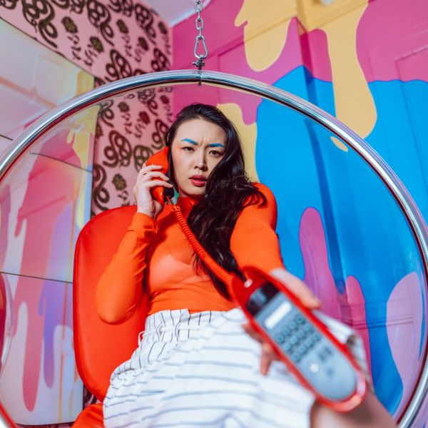 Person in bold colors with a bright orange phone calling NeuroSpark Health.